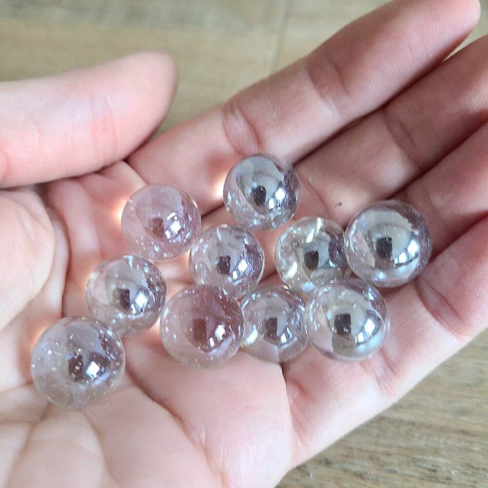 10 clear iridescent glass marbles.